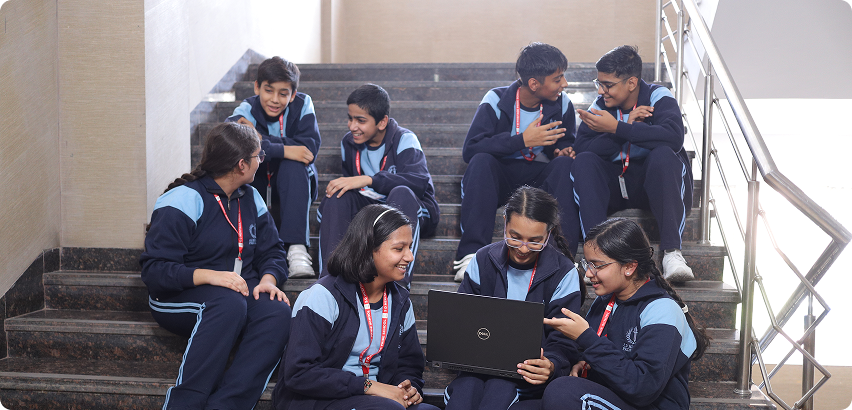 Students engaged in collaborative laptop learning on stairs
